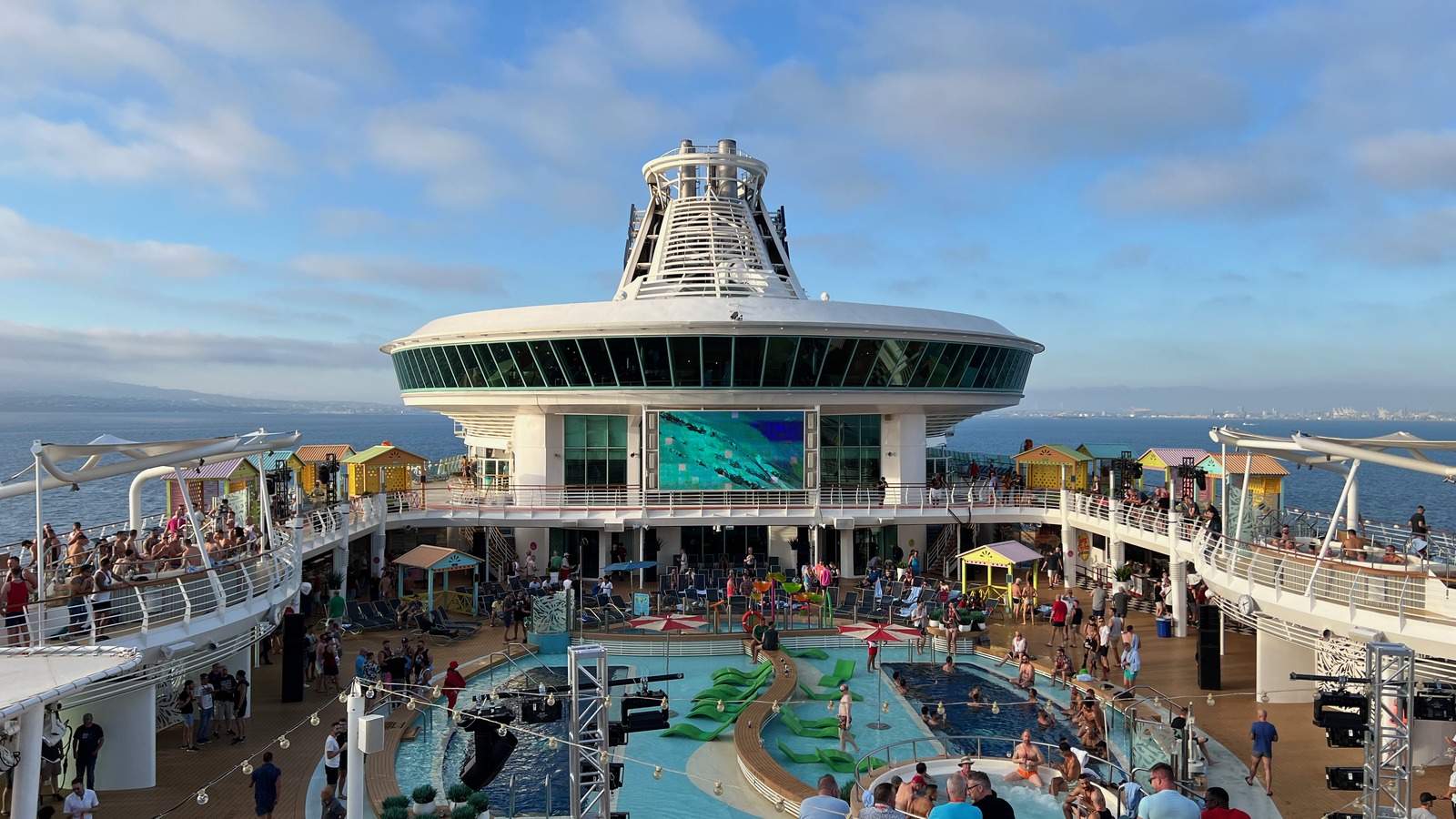 Navigator of the Seas pool deck and Viking Crown Lounge in daylight with passengers around the pool