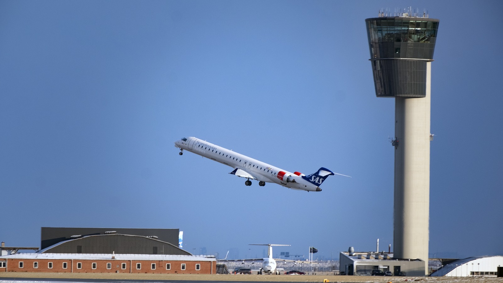 A SAS aircraft climbing out of Copenhagen Airport beside the control tower