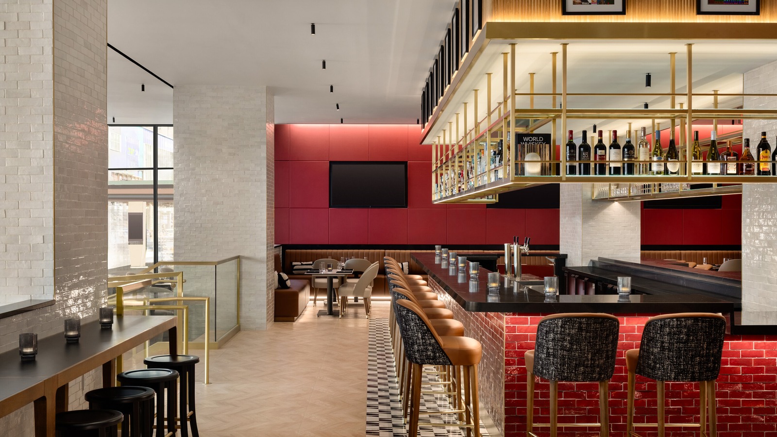 Interior of Fifty-First Street Social at Crowne Plaza Manhattan Times Square, with a red-brick bar, brass wine racks, and dining booths