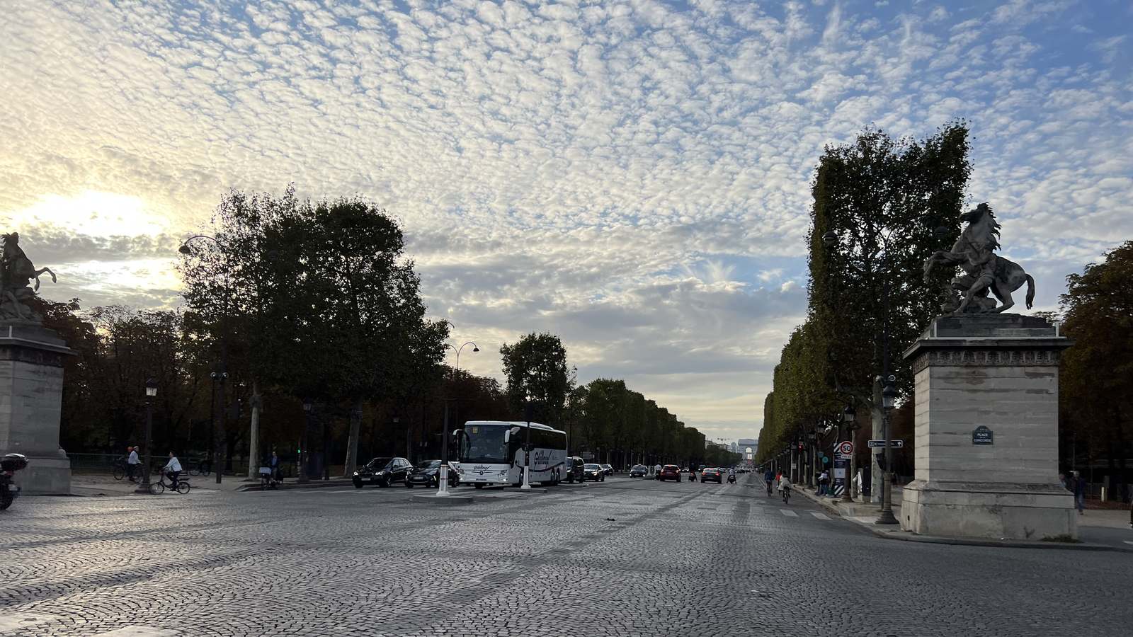 The Avenue des Champs-Elysees seen from the Place de la Concorde, with the Arc de Triomphe in the distance and traffic on the cobbles