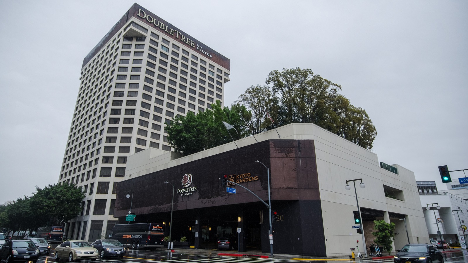 DoubleTree by Hilton hotel tower and street-level entrance on a wet city block
