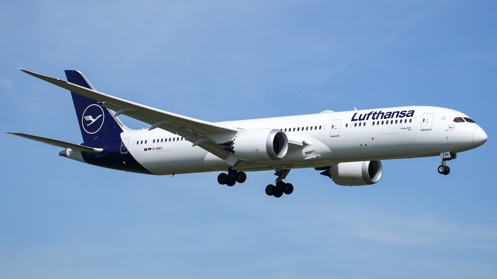 Lufthansa Boeing 787-9 registered D-ABPC on approach at Frankfurt Airport with landing gear down against a blue sky.
