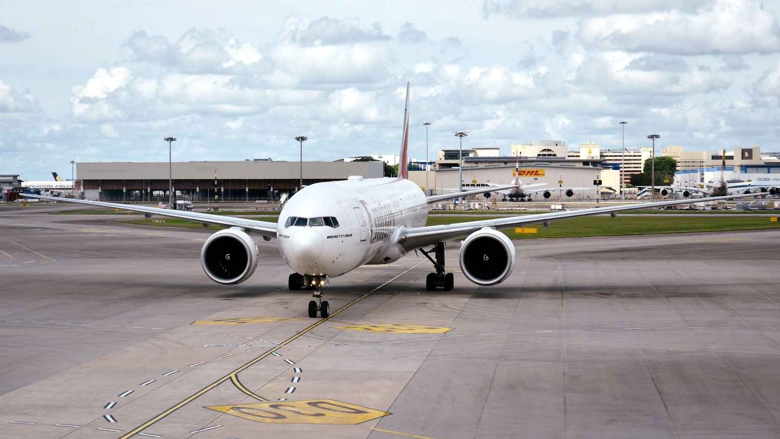 An Emirates Boeing 777-300ER taxiing head on with the Boeing 777-300ER nose titles and the Emirates livery clearly visible.