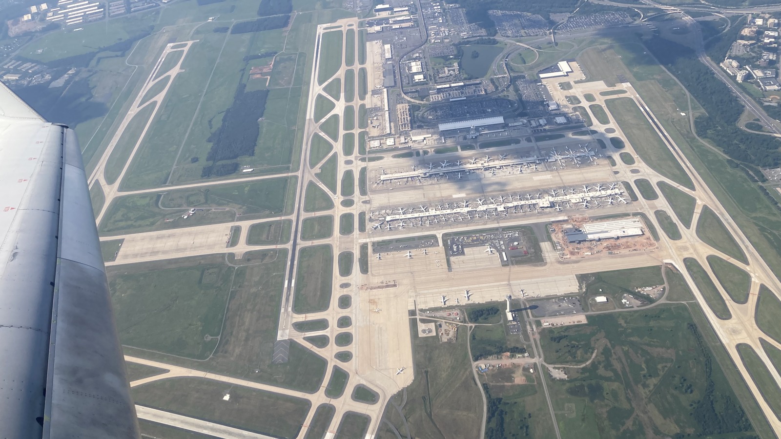 Aerial view from the south of Washington Dulles International Airport in July 2025, showing the main terminal and parallel runways