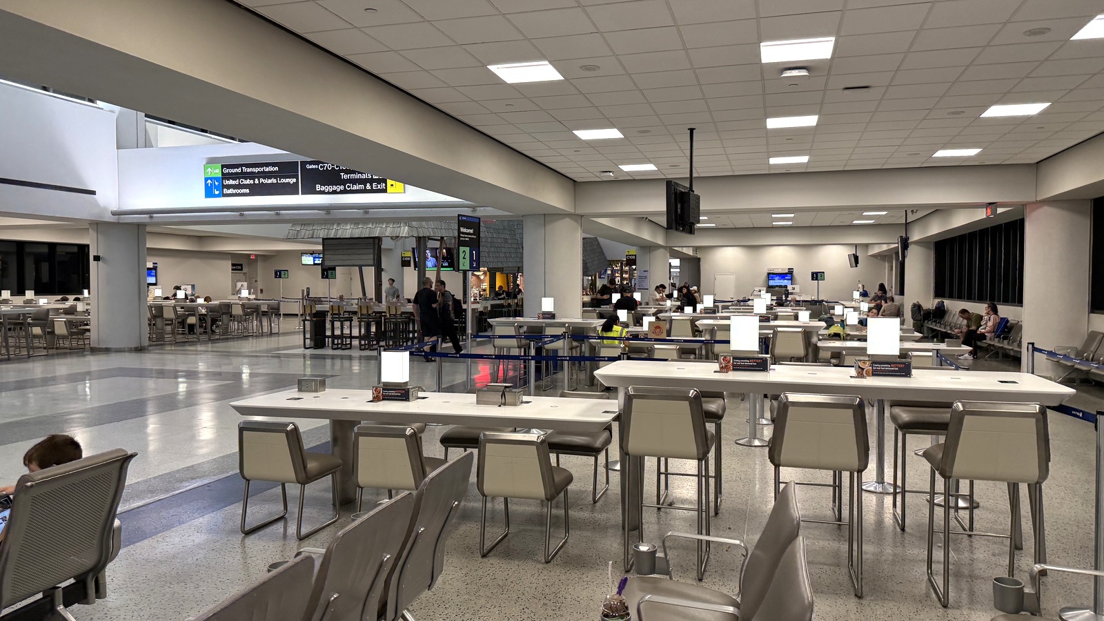 Interior of Terminal C at Newark Liberty International Airport, with United Club wayfinding and gate seating