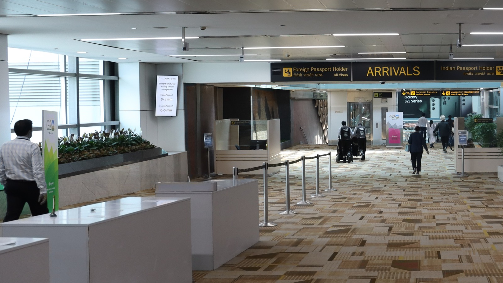Arrivals hall inside Indira Gandhi International Airport in New Delhi with arrivals signage and passengers walking toward immigration.