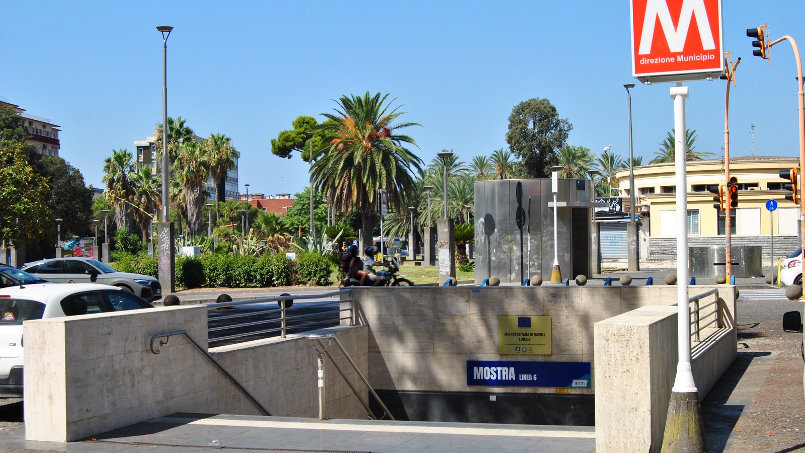 The street entrance to Mostra station on Naples metro Line 6, with a sign reading MOSTRA Linea 6 beside the anm logo and a red M sign above reading direzione Municipio