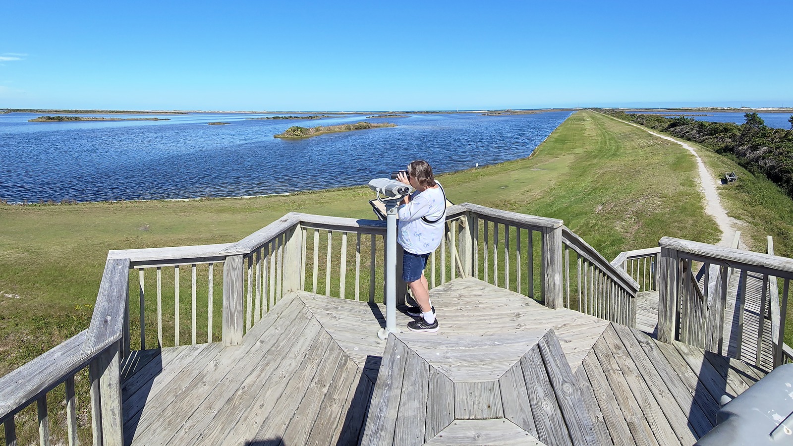 Observation deck overlooking marsh and open water at Pea Island National Wildlife Refuge near Hatteras Island, North Carolina, in daylight