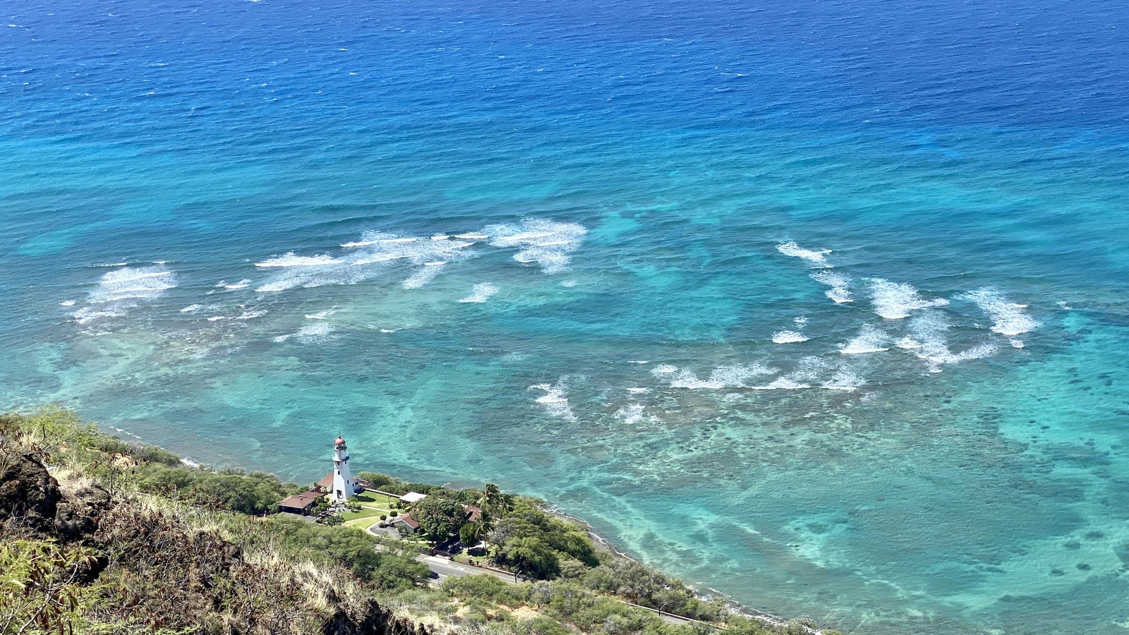 Diamond Head Lighthouse and the turquoise Oahu coast seen from Diamond Head Crater, Honolulu, Hawaii.