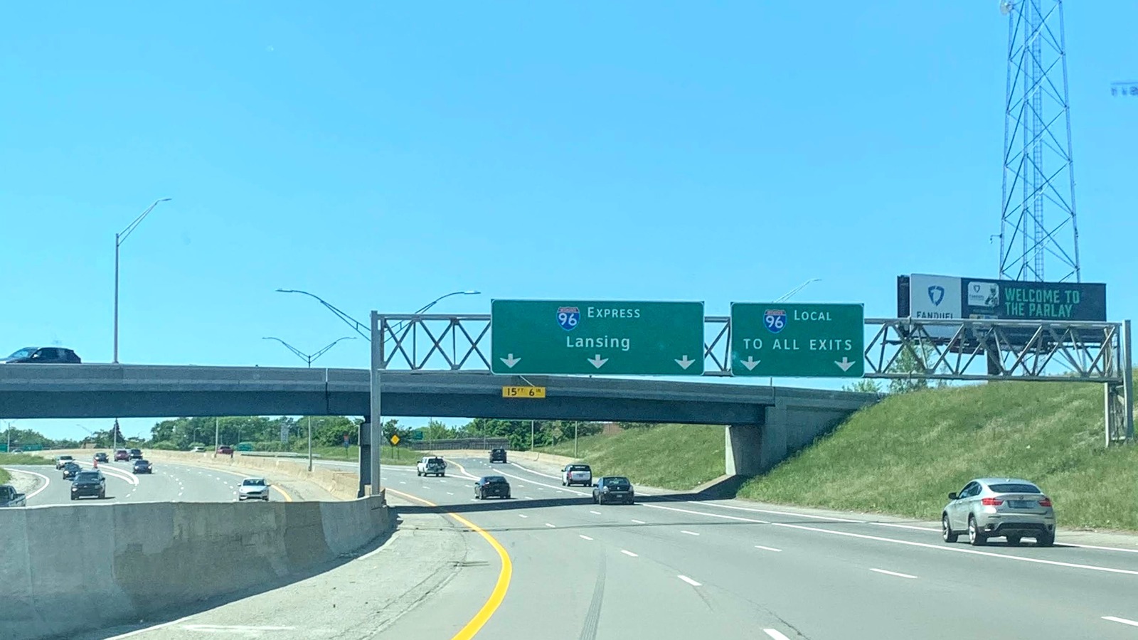 Daytime view of Interstate 96 in Michigan approaching the overhead gantry that splits the Express and Local lanes