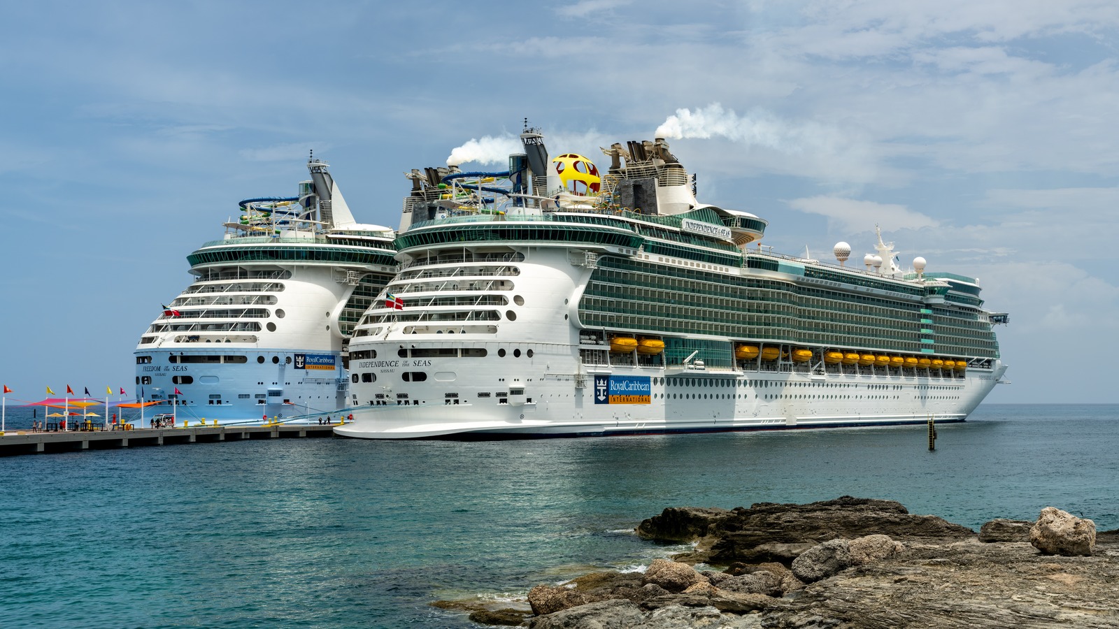Royal Caribbean Independence of the Seas and Freedom of the Seas docked at a sunny port