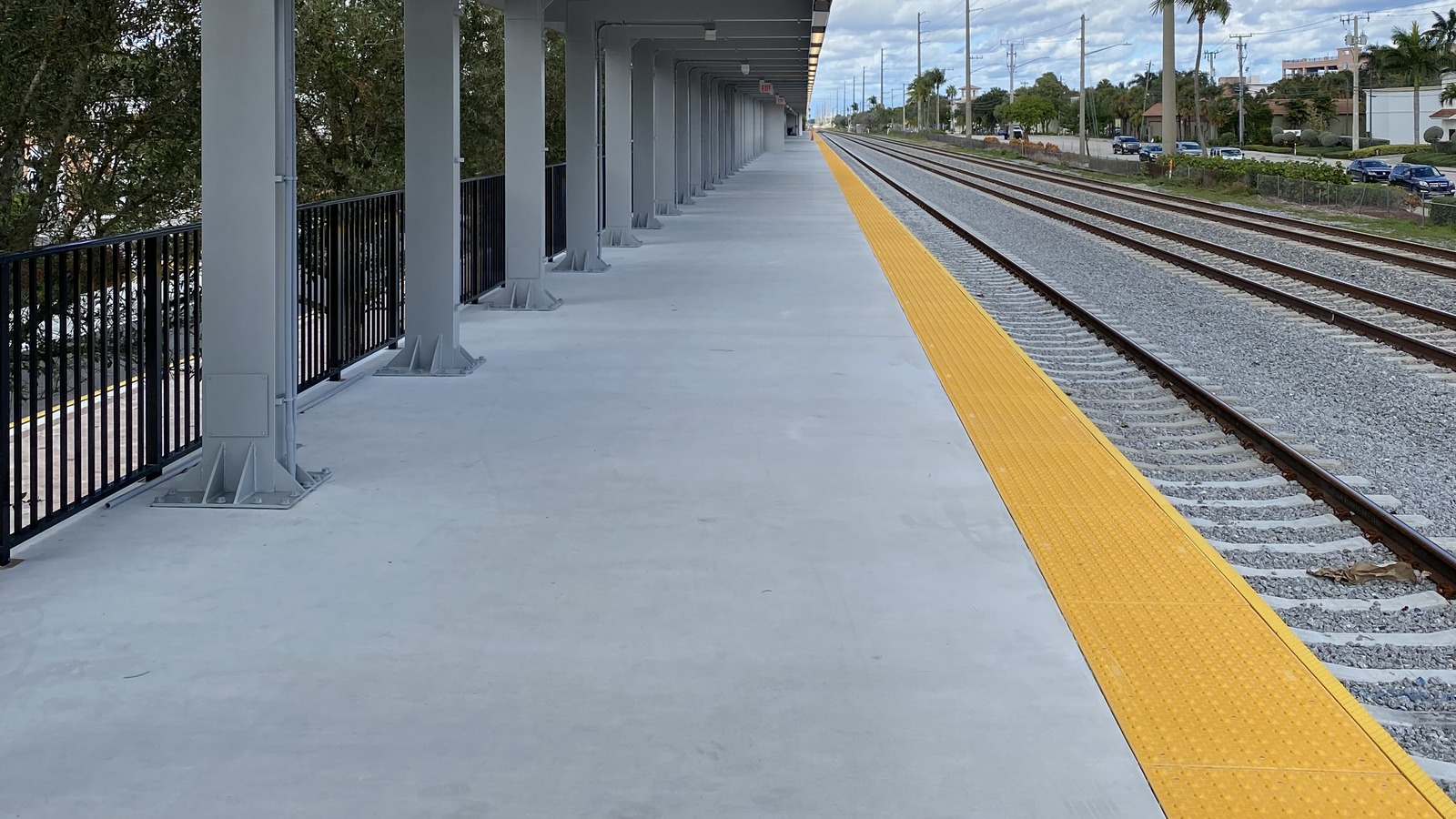 Train platform and tracks at Boca Raton Brightline station under a canopy