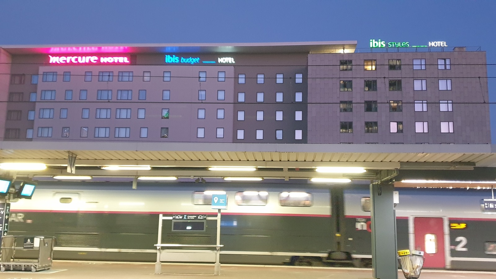 Night view of Accor Mercure, ibis budget, and ibis styles hotels above a railway platform