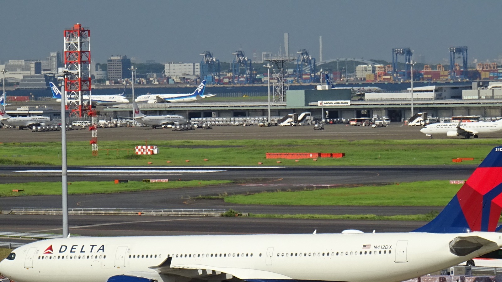 Delta Air Lines Airbus A330 N412DX on the ramp at Tokyo Haneda Airport with Japan Airlines buildings in the background