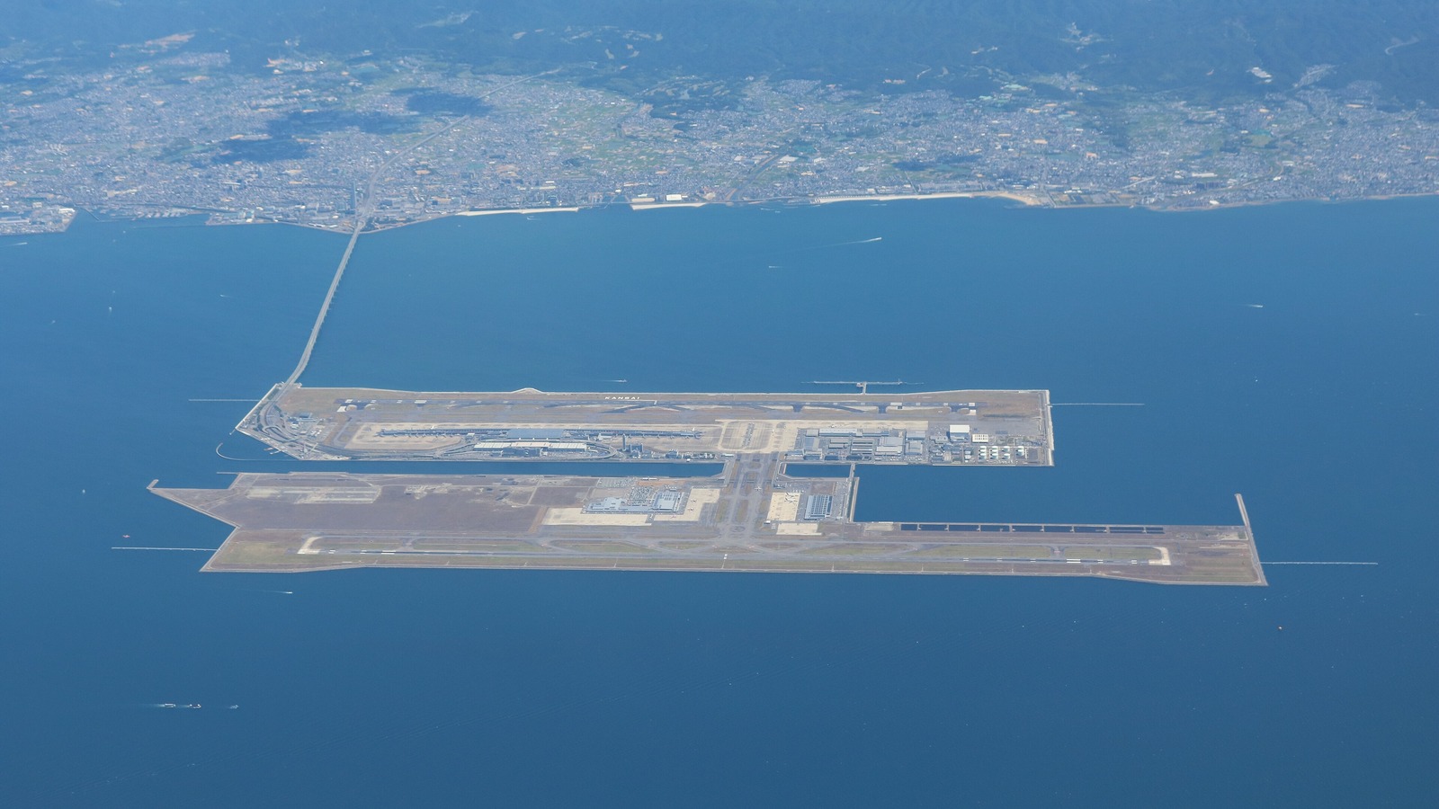 Aerial view of Kansai International Airport's two man-made islands in Osaka Bay, linked to the mainland by a long bridge, in August 2022.
