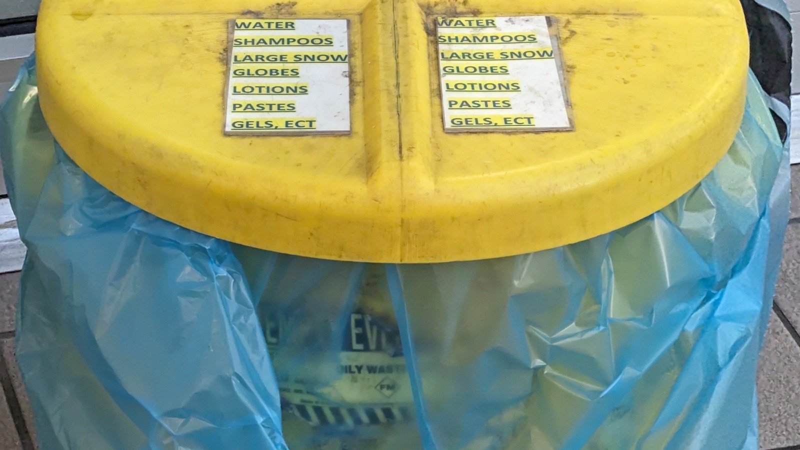 Yellow TSA checkpoint bin for surrendered liquids and gels at Orlando Airport