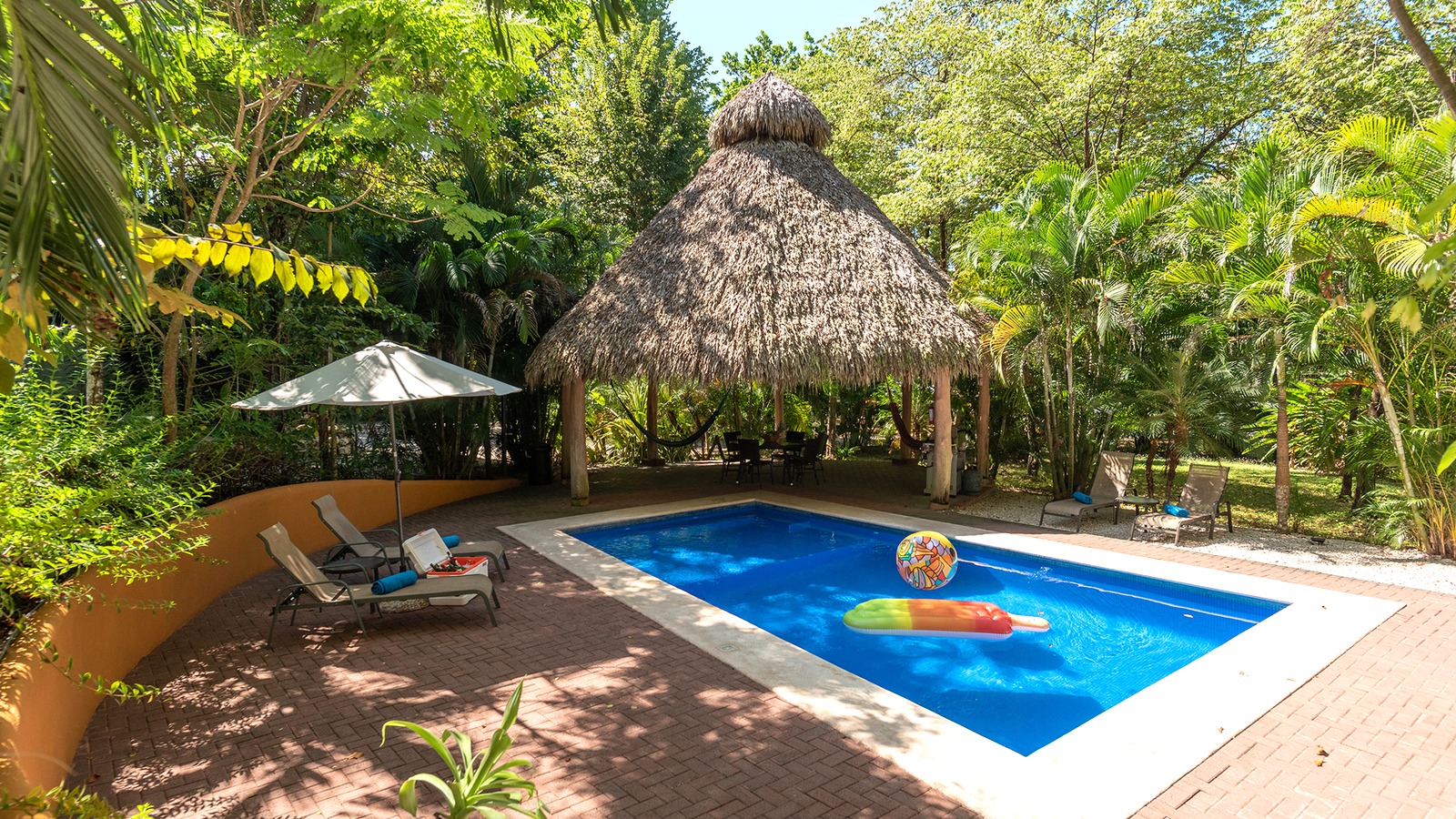 Pool, thatch palapa, and lounge chairs at an Airbnb vacation rental in Mal Pais, Costa Rica