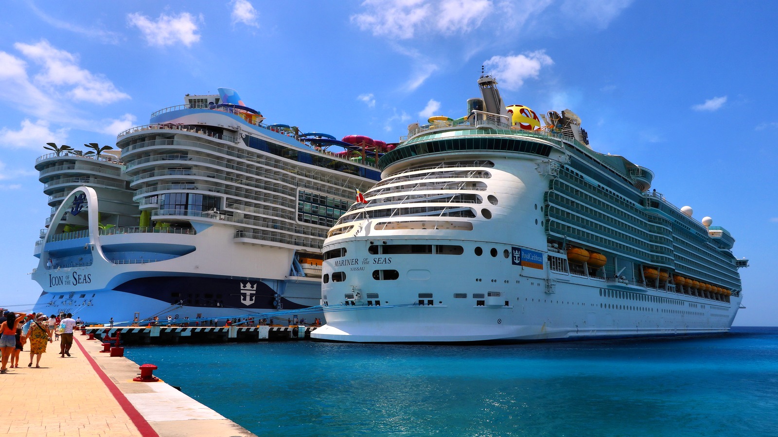 Icon of the Seas docked in Cozumel, Mexico, beside Mariner of the Seas on a clear day, with the Icon name visible on the bow.