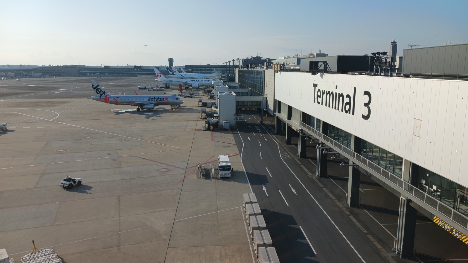 Narita International Airport Terminal 3 exterior with parked aircraft in daylight