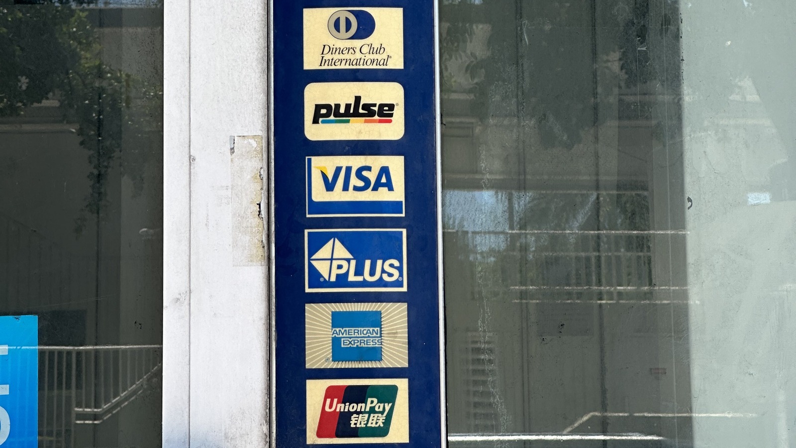 Card network acceptance marks including the Visa logo displayed on a merchant door