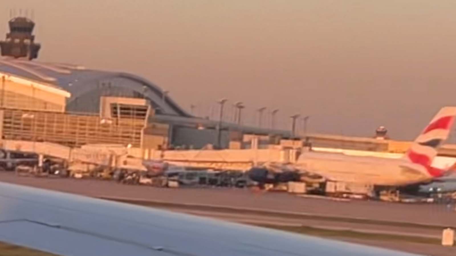 Dallas Fort Worth International Airport terminal, aircraft wing, and control tower from the airfield