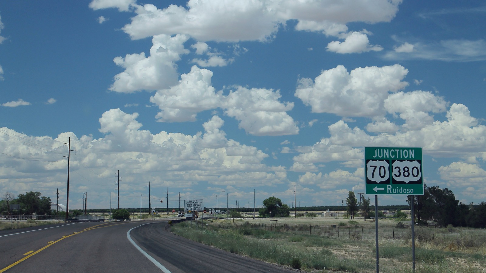 Highway junction signs pointing toward Ruidoso, New Mexico, on an approach road