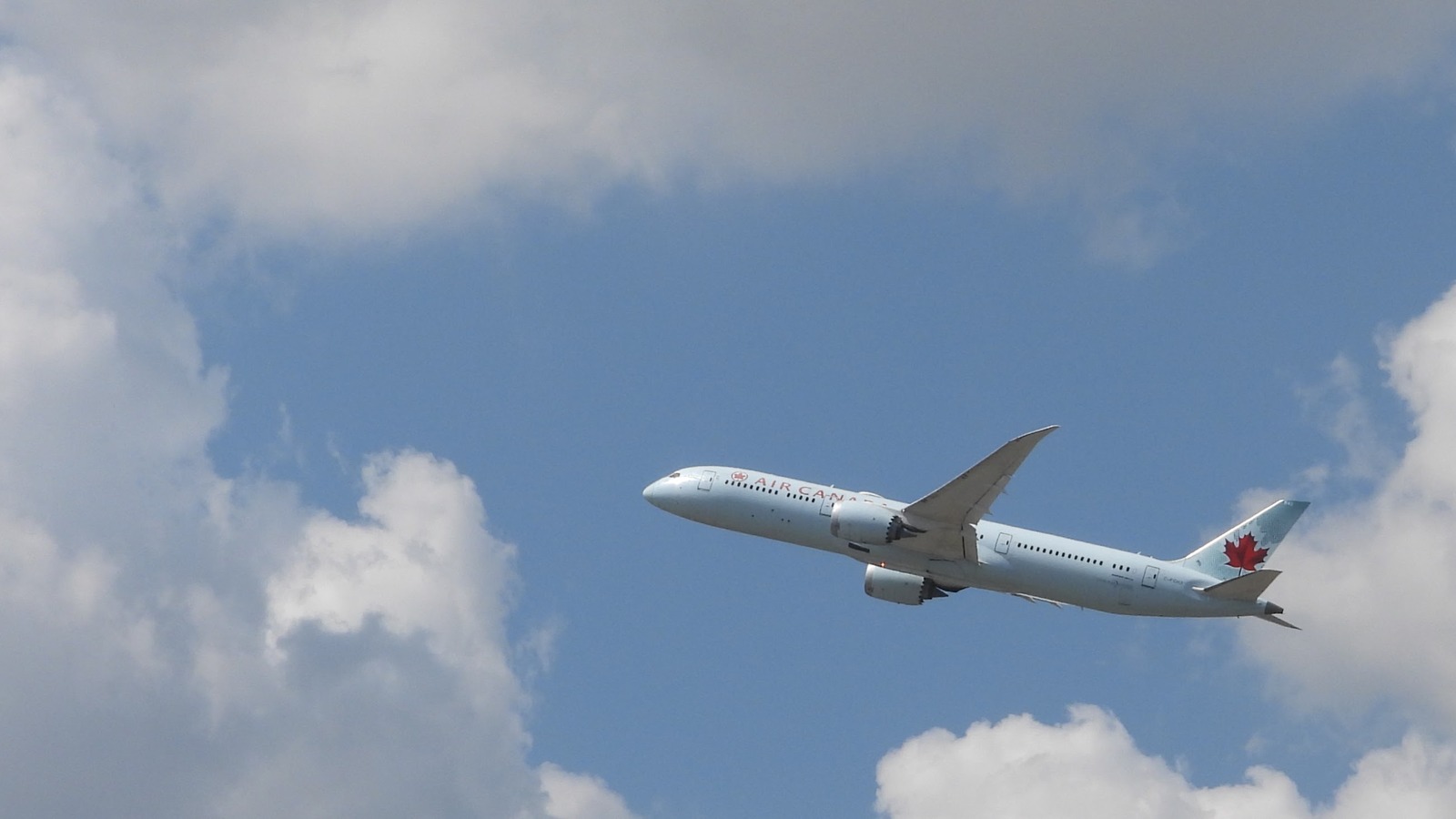 Air Canada Boeing 787 climbing after departure from Toronto Pearson under a blue sky