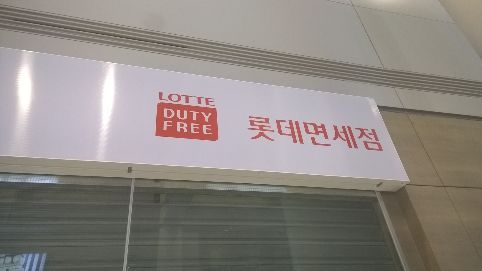 Lotte Duty Free sign in English and Korean above a storefront at Incheon International Airport.