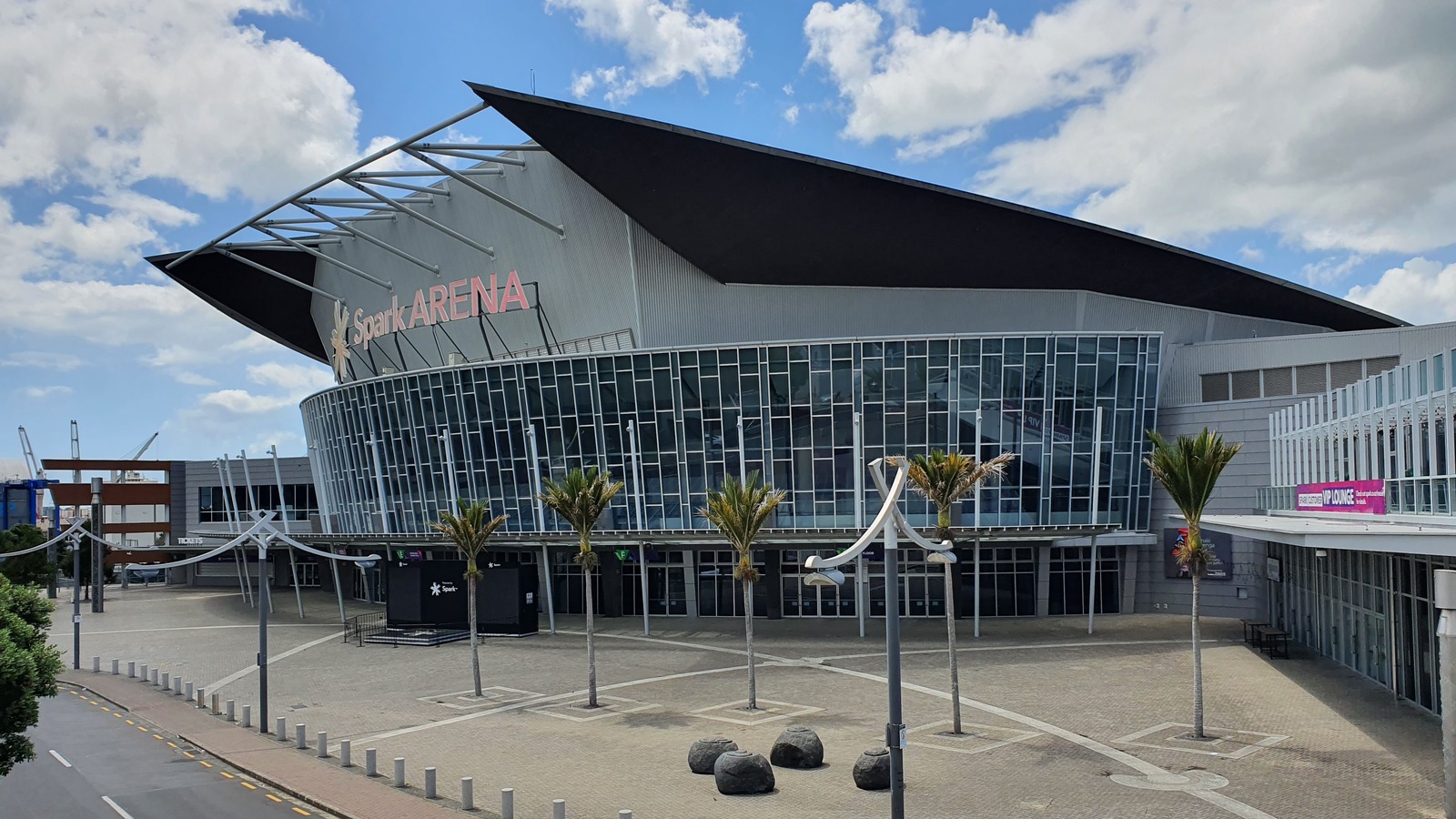Daylight exterior of Spark Arena in Auckland, with the Spark ARENA sign above the glass entrance and plaza