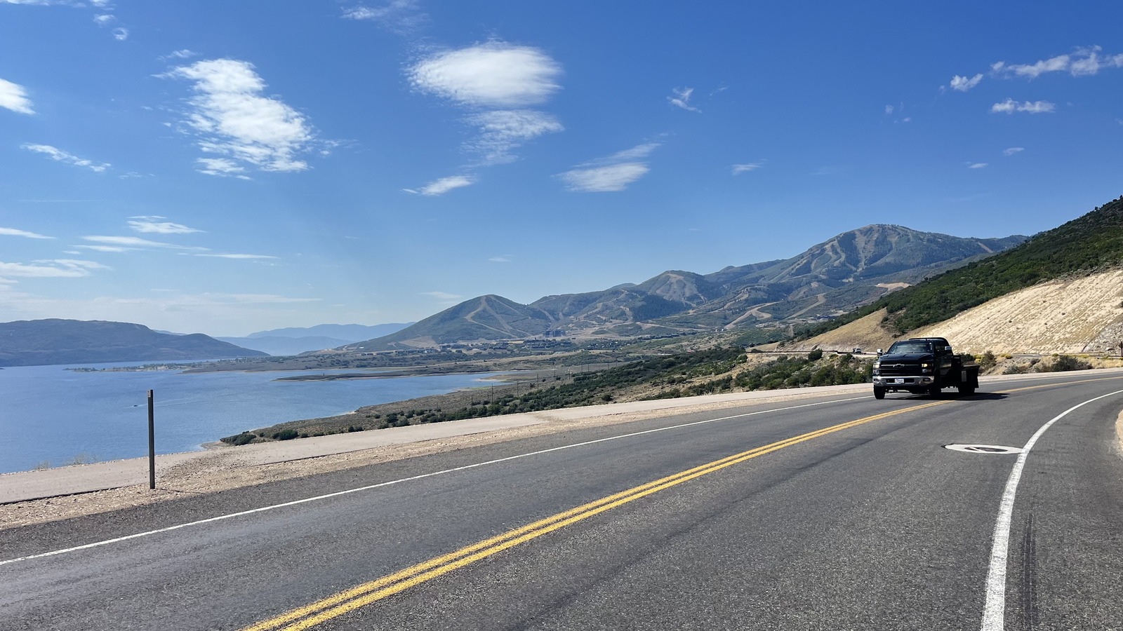 Deer Valley slopes beyond Jordanelle Reservoir, viewed from a roadside in September 2024