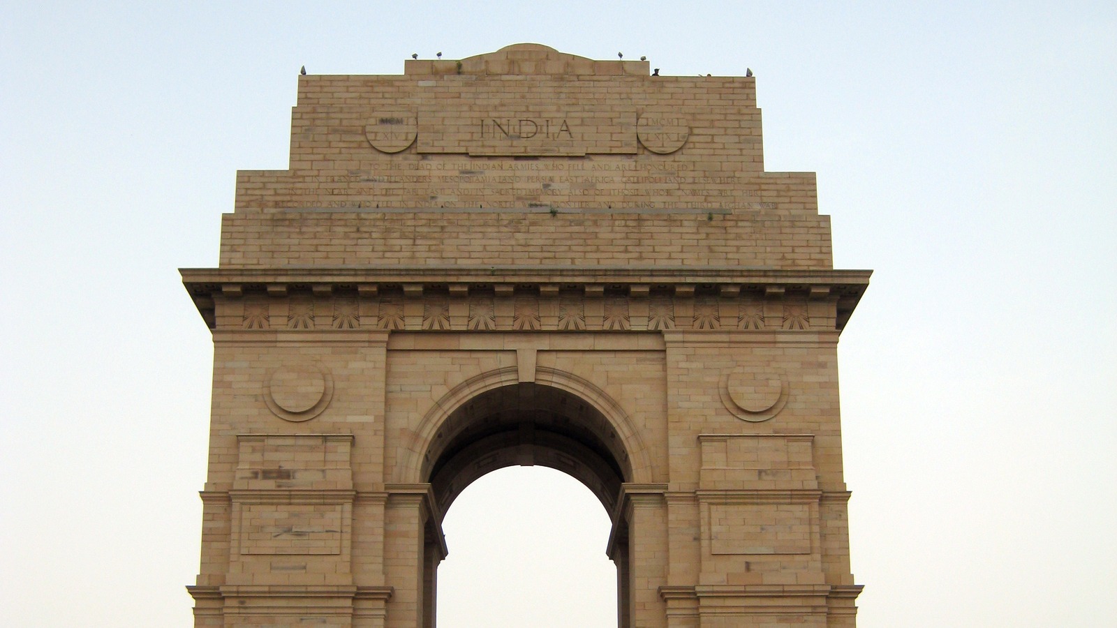 India Gate landmark in New Delhi under a pale sky