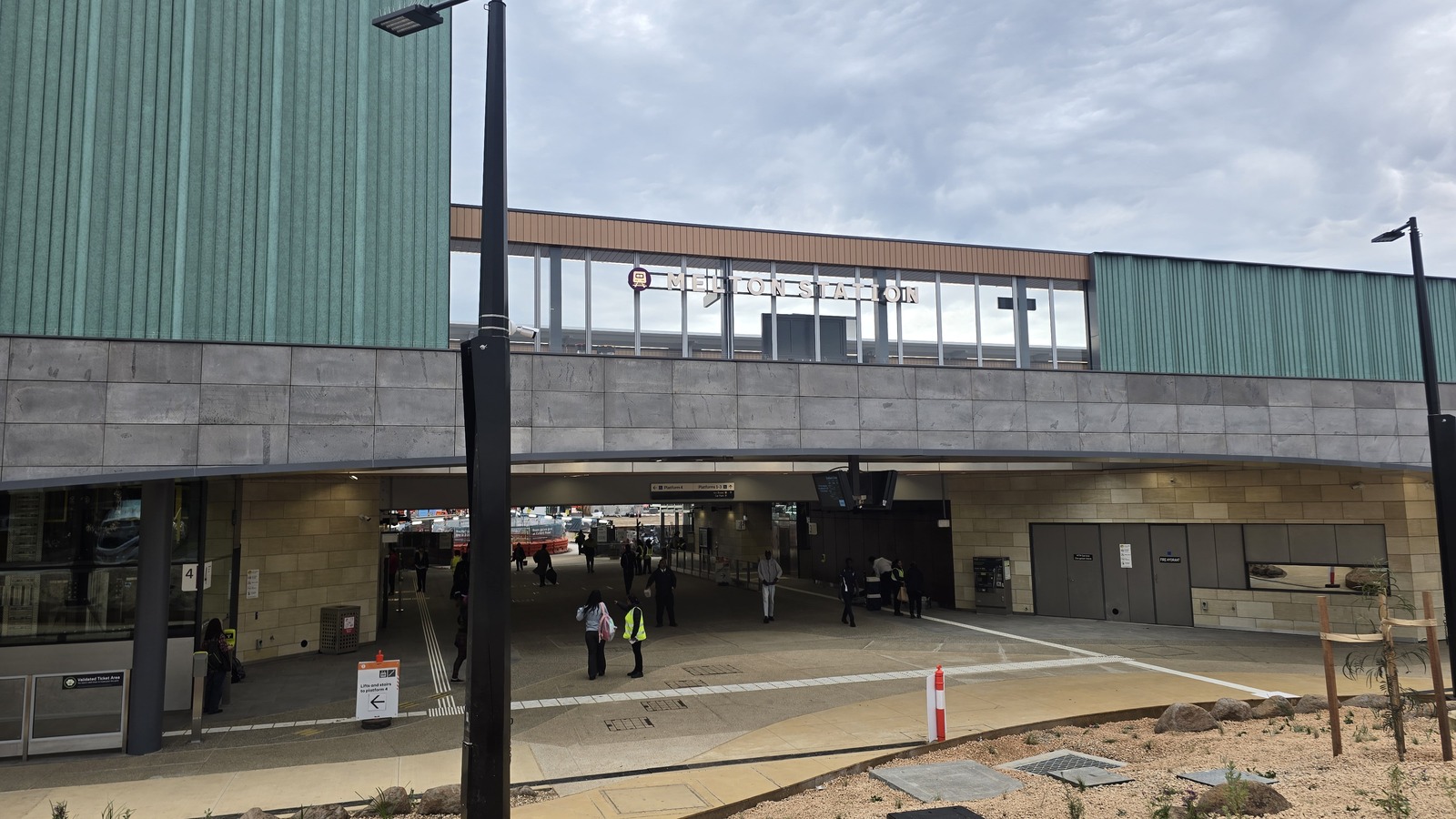 The new Melton Station building and underpass on opening day, with the station name on the elevated facade and passengers in the concourse below.