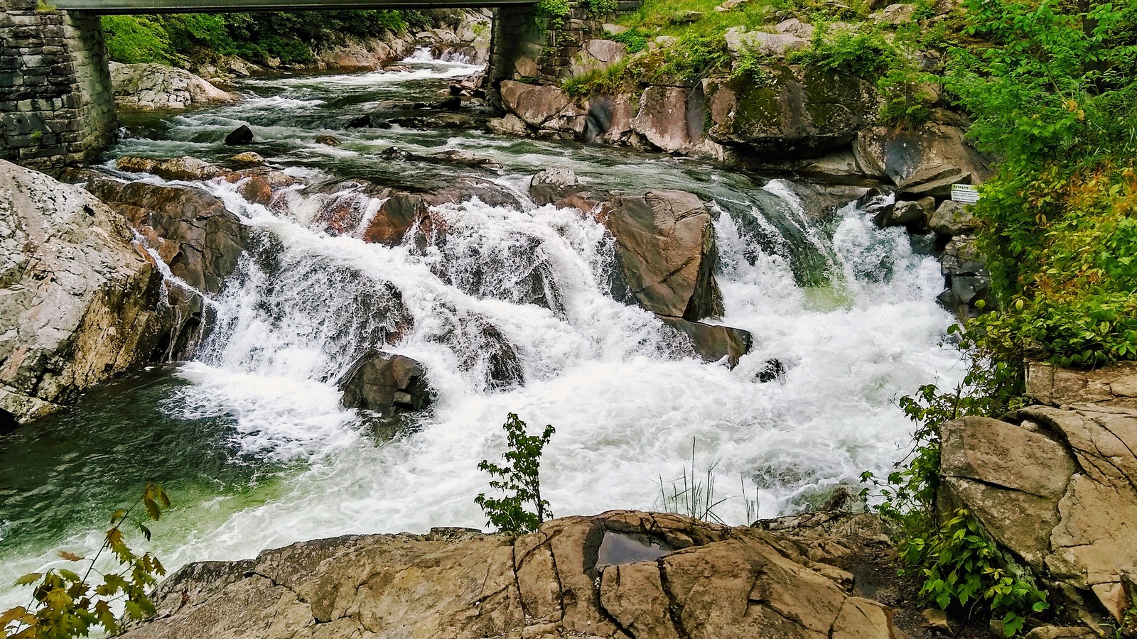 The Sinks waterfall on Little River under a stone bridge in Great Smoky Mountains National Park
