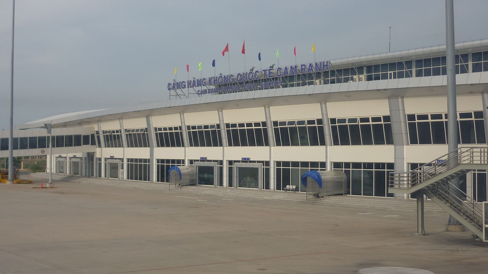 Cam Ranh International Airport terminal exterior with bilingual rooftop signage facing the airside apron