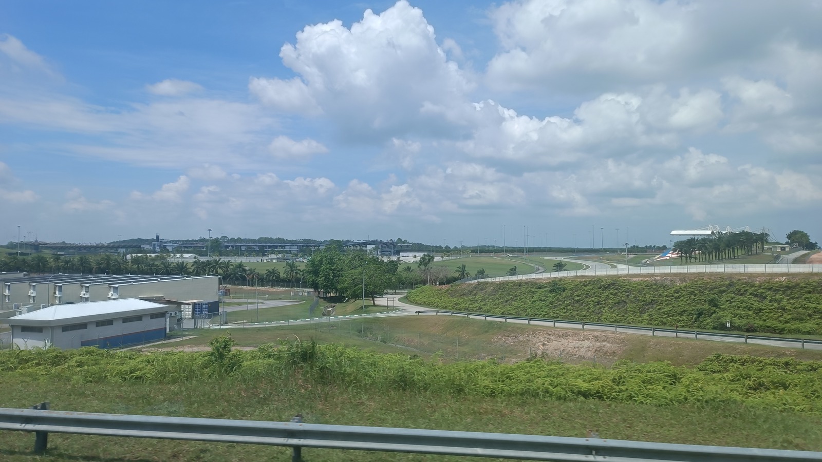 Daytime exterior view of Sepang International Circuit showing the track, grandstand, and surrounding grounds