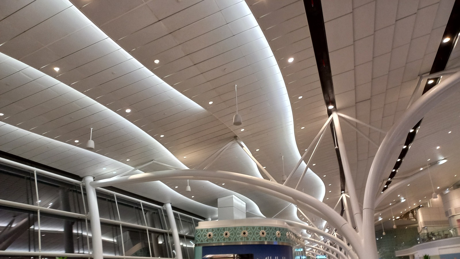 Curved white ceiling and tree-like columns inside King Abdulaziz International Airport in Jeddah