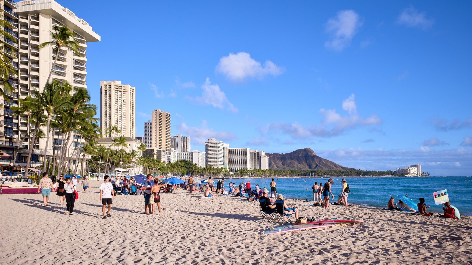 Waikiki Beach in Honolulu, Hawaii, with hotels, beachgoers, and Diamond Head in the distance