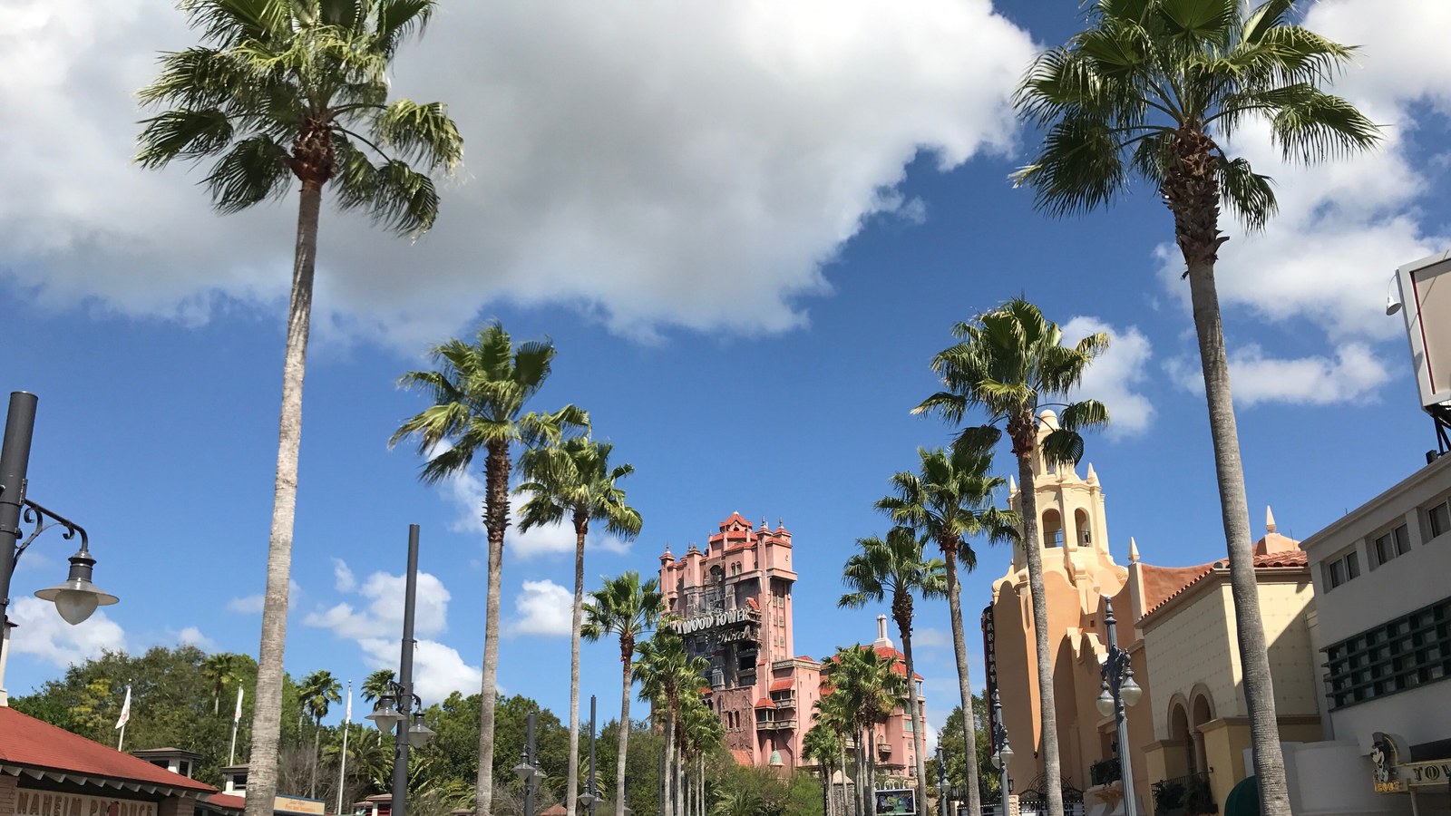 Sunset Boulevard at Disney's Hollywood Studios looking toward the Hollywood Tower Hotel, with palms lining the street and the tower closing the view at the end