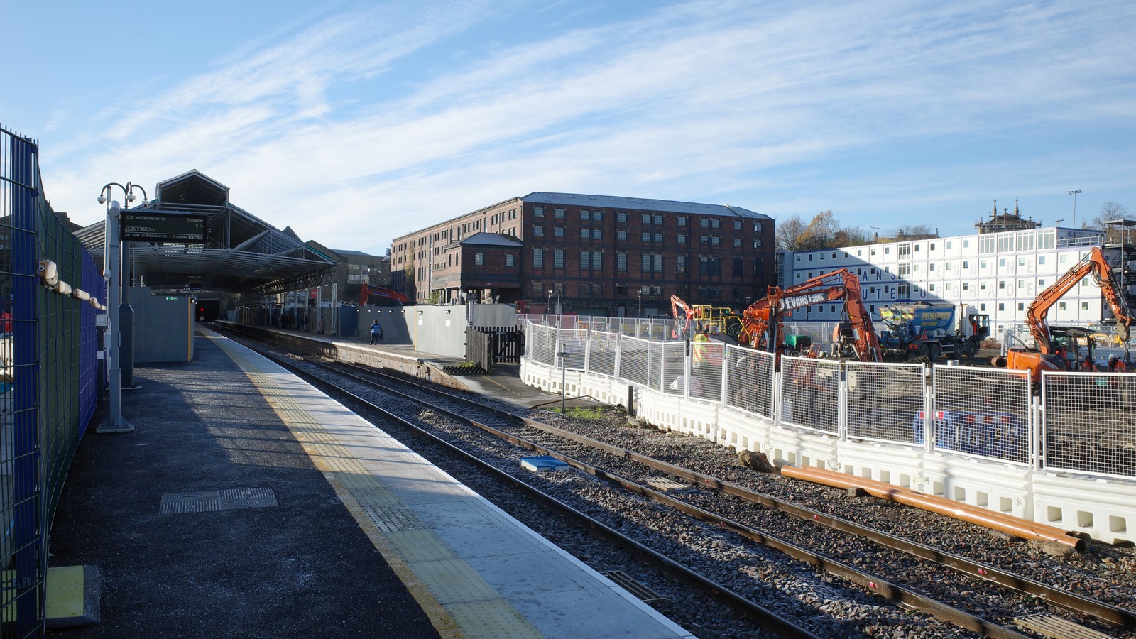 Platform 2 at Huddersfield railway station during redevelopment work, with construction hoarding alongside the platform