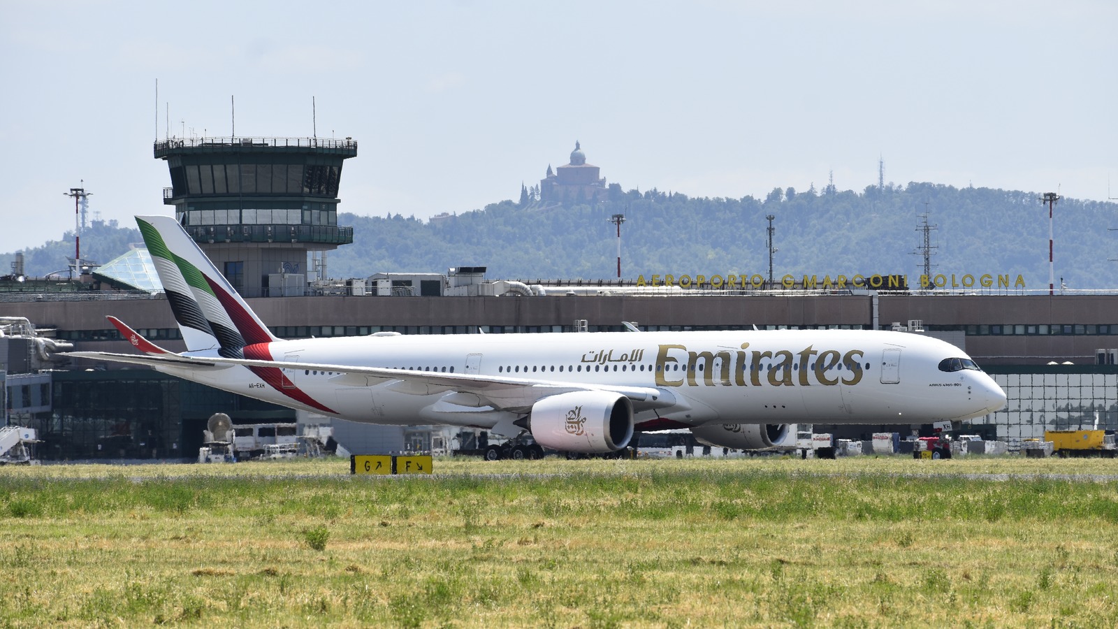 Emirates Airbus A350-900 taxiing at Bologna Airport with the airline name readable on the fuselage