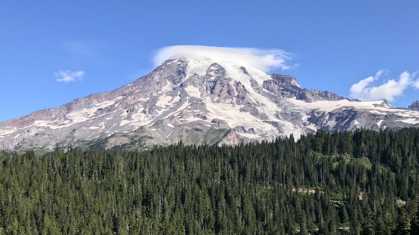 Snowcapped Mount Rainier above a forested valley, photographed from Inspiration Point on Stevens Canyon Road