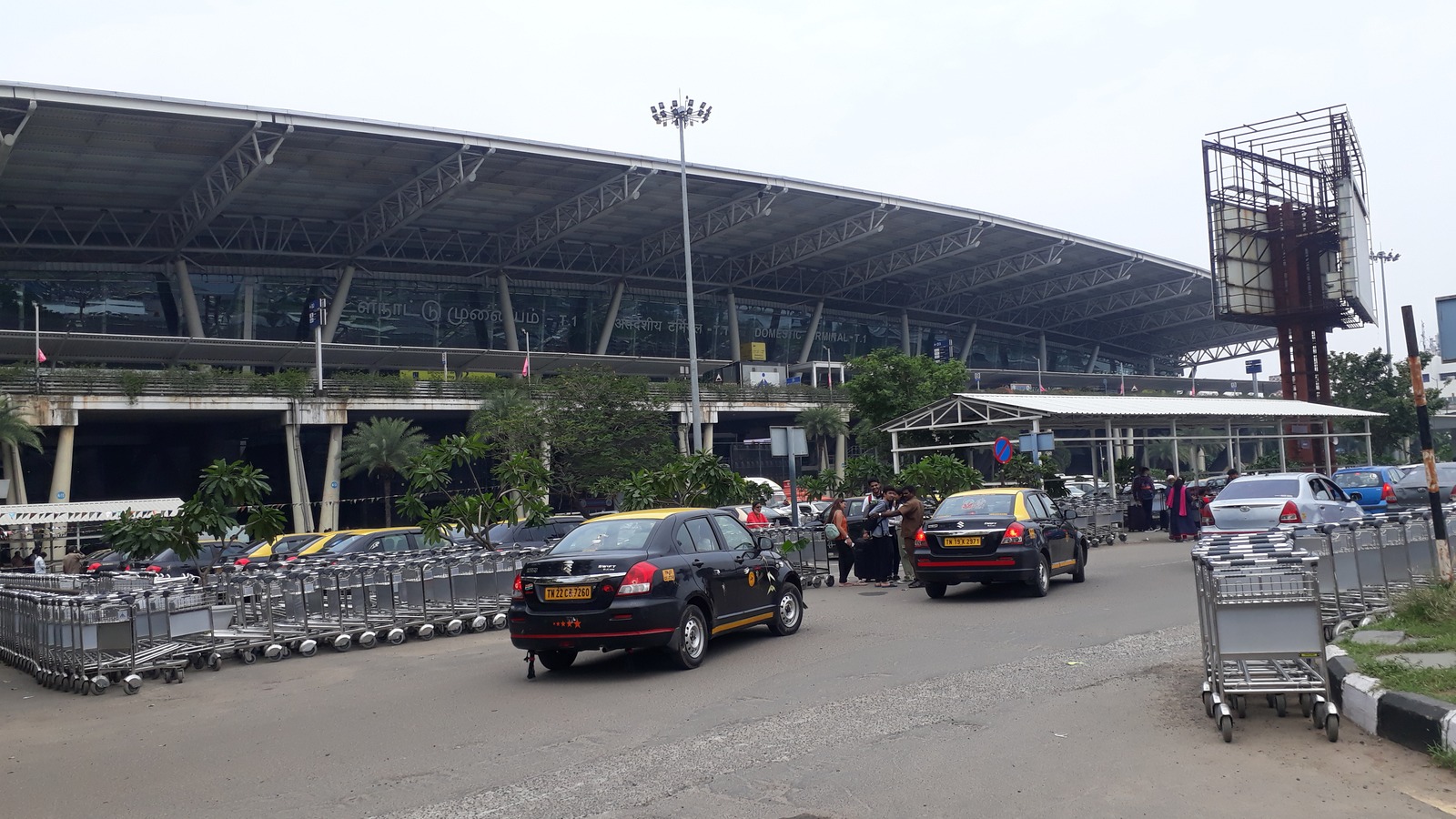Landside of Chennai Airport Domestic Terminal T-1 with taxis and baggage carts