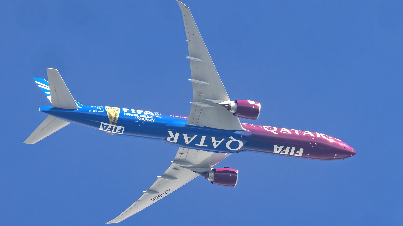 Qatar Airways Boeing 777 aircraft flying against a clear blue sky