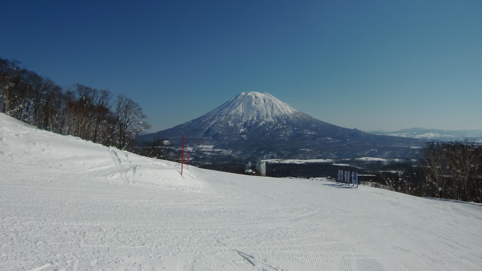 Snow-covered Namara ski slope in Niseko Village with Mount Yotei under a clear winter sky