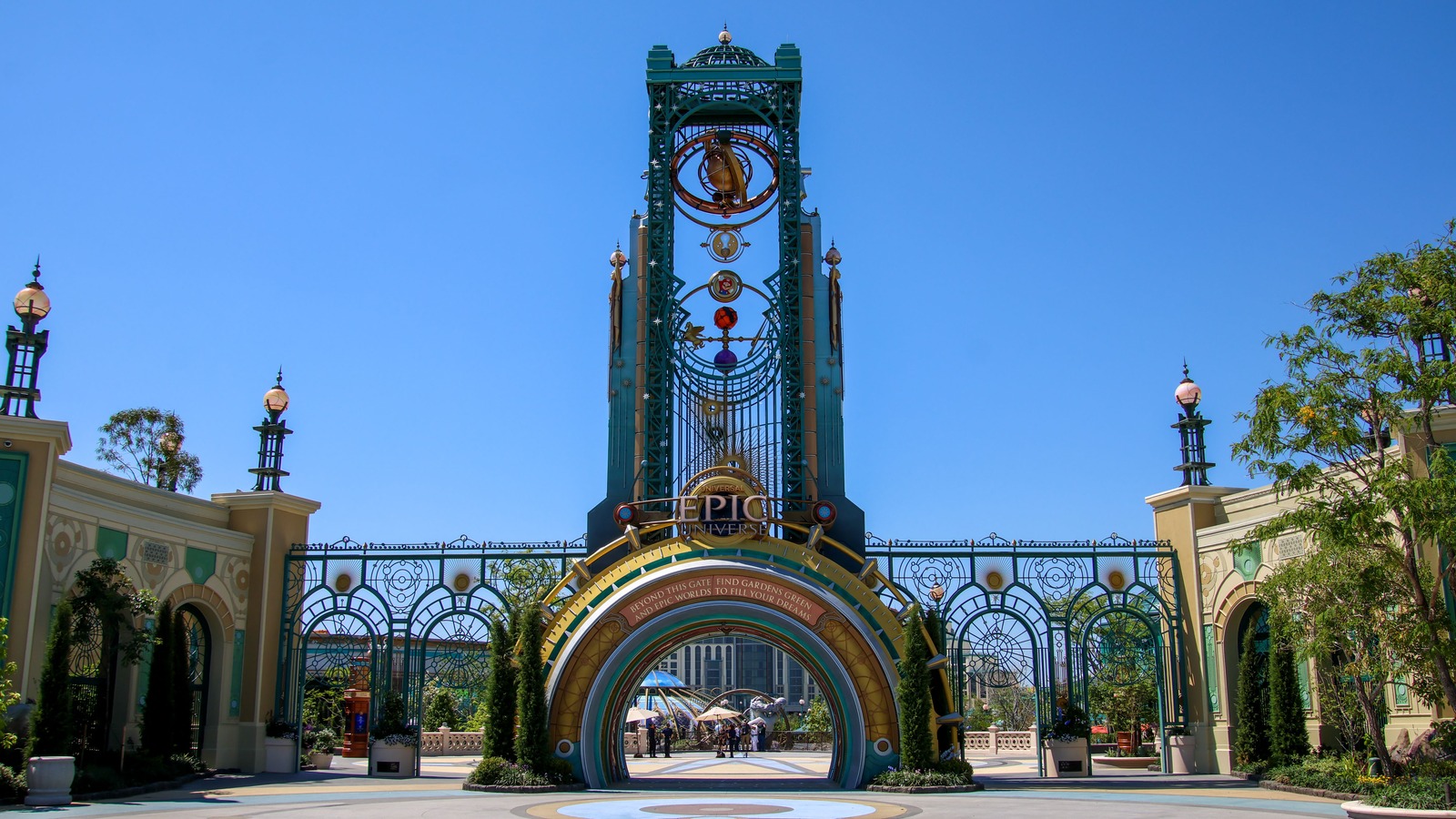 Chronos Tower and entrance gates at Universal Epic Universe in Orlando under a clear blue sky