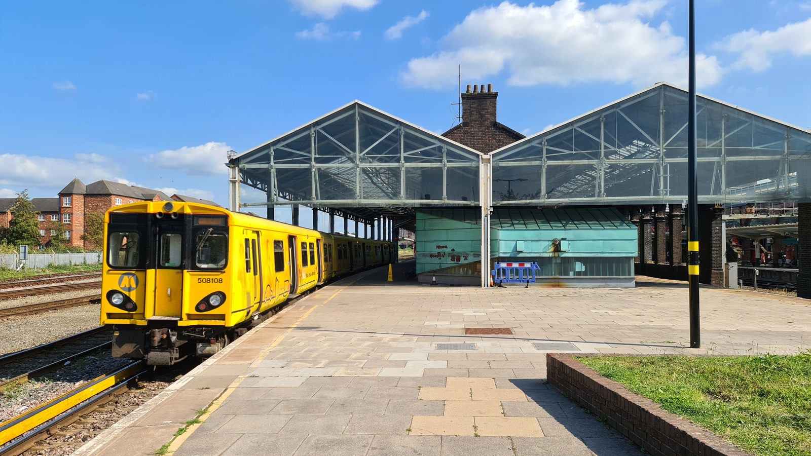 A Merseyrail electric train standing at a platform with a Liverpool destination display