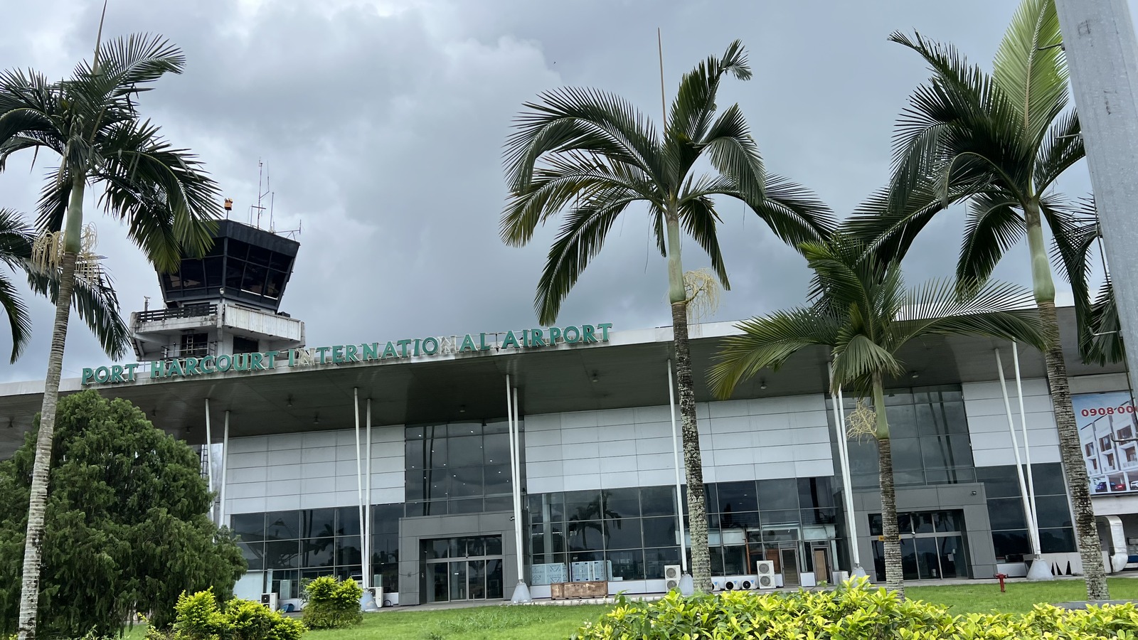 Port Harcourt International Airport terminal exterior with control tower and palm trees