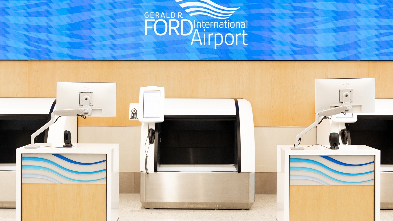 Self-service baggage drop units below Gerald R. Ford International Airport signage