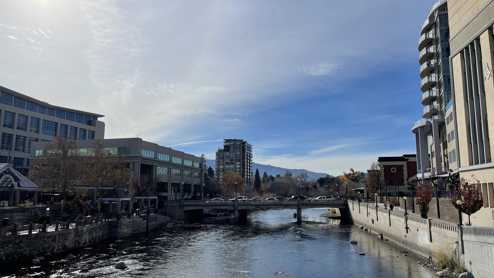 The Truckee River running through downtown Reno past buildings and a road bridge on a clear day