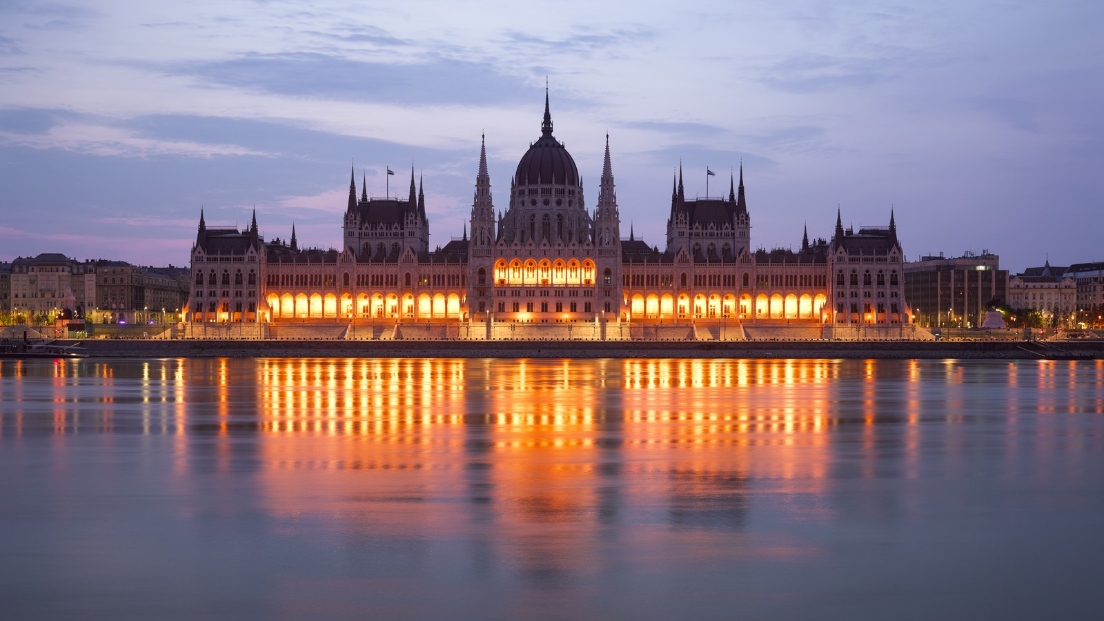 Hungarian Parliament Building on the Danube at dusk with lights reflecting on the river in Budapest